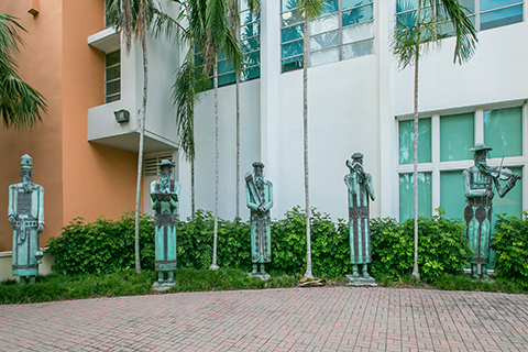 A photograph of a sculpture collection titled, "Five Figures." This collection is displayed outside of the Sue and Leonard Miller Center for Contemporary Judaic Studies.