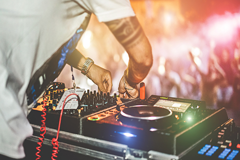 This is a stock photo. An up close image of a DJ and their turn tables. 