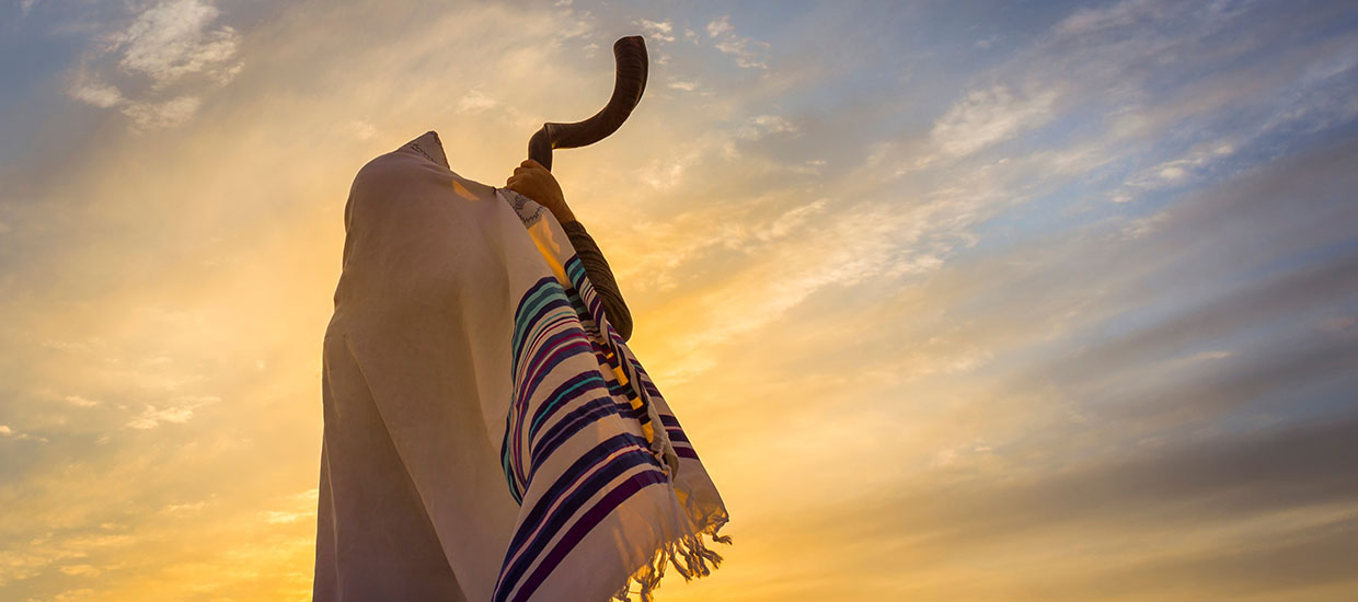 This is a stock photo. A man blowing the Shofar horn.